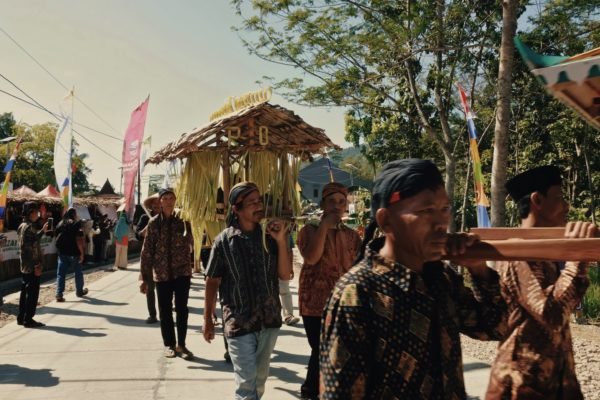 Villagers carry their produce during the parade